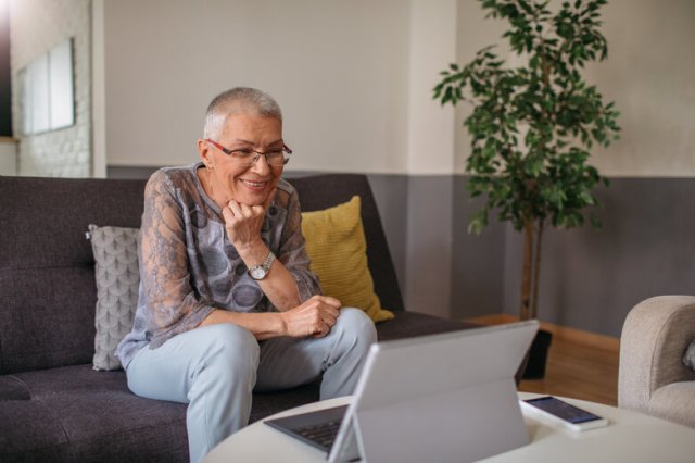 Smiling Senior Woman Using Tablet At Home