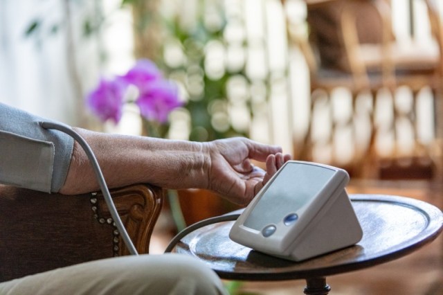 senior-woman-using-digital-blood-pressure-monitor-picture-id1058889572