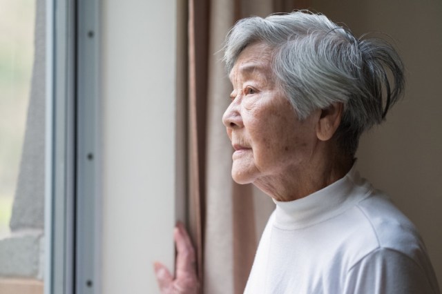 serious-asian-senior-woman-in-90s-looking-out-of-window-picture-id1296945064