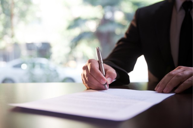 businessman-signing-contract-or-legal-papers-picture-id1296962121