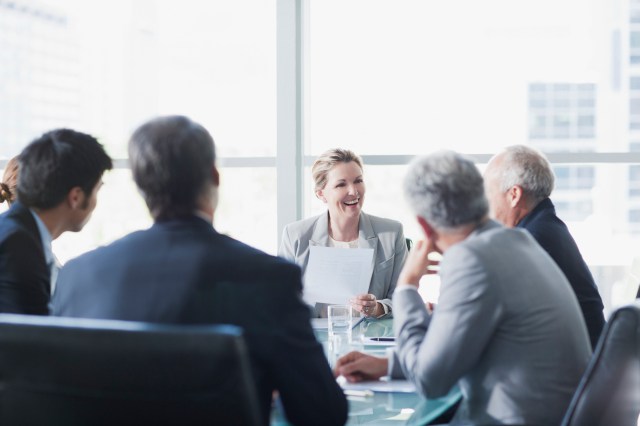 Smiling businesswoman leading meeting in conference room