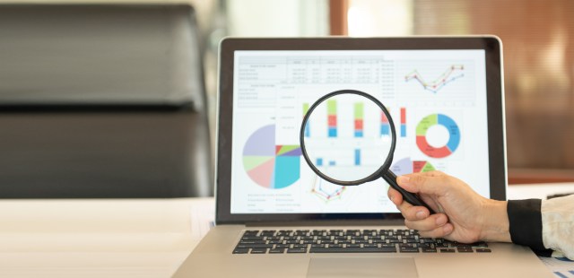 Magnifying glass with financial report. Analysis of financial statements and review annual report for evaluation of financial performance and position of organisation.
