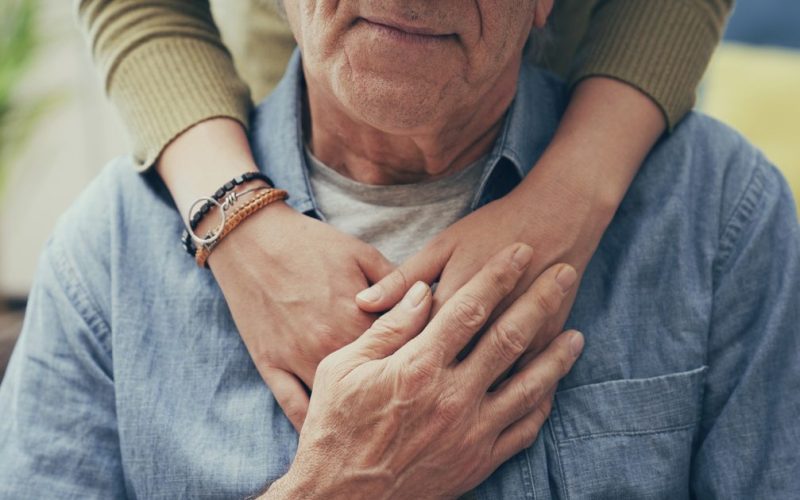 Comforting hand on shoulder of man