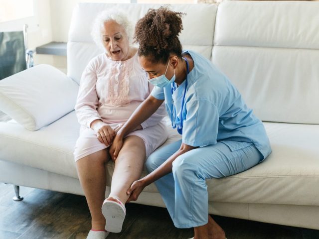 Senior woman getting physical therapy treatment at home