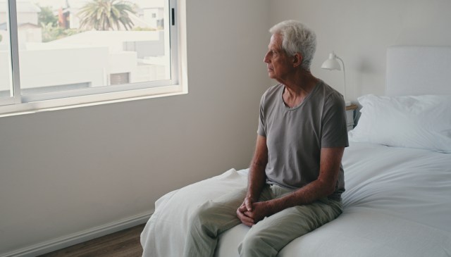 Thinking, bed and senior man with retirement, sad and anxiety with depression, home and memory with Alzheimer. Old person, pensioner or elderly guy with stress, bedroom or remember with mental health