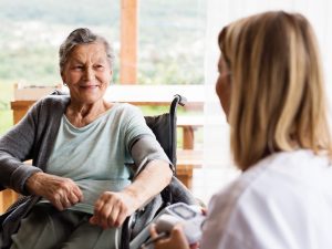 Health visitor and a senior woman during home visit.